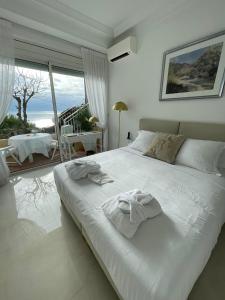 a bedroom with a large white bed with towels on it at Hôtel Le Roquebrune in Roquebrune-Cap-Martin