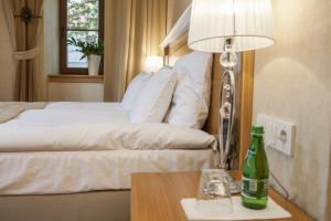 a bedroom with a bed and a bottle on a table at Hotel Alhambra in Lądek-Zdrój