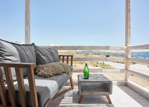 a couch on a porch with a view of the beach at Nirome Luxury Suites in Adamantas