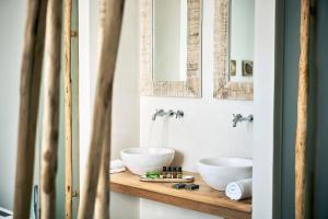 a bathroom with two sinks and two mirrors at Nirome Luxury Suites in Adamantas