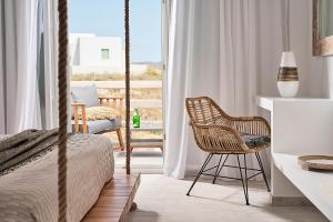 a bedroom with a bed and a desk and chair at Nirome Luxury Suites in Adamantas