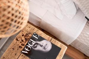 a magazine on a table next to a bed at Nirome Luxury Suites in Adamantas