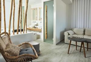 a living room with a rattan chair and a couch at Nirome Luxury Suites in Adamantas