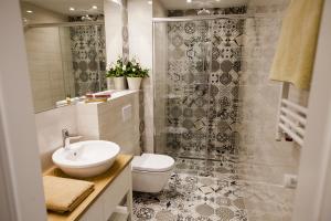 Hotel Alhambra في لوندك زدرووي: حمام مع حوض ومرحاض ودش