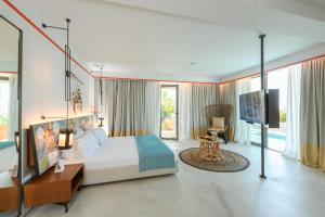a bedroom with a large bed and a flat screen tv at Folie Marine Hotel & Beach Club in Jal +274 photos