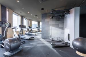 einen Fitnessraum mit mehreren Laufbändern und Crosstrainern in der Unterkunft Optimum Apartment - Wolframplatz in Zürich