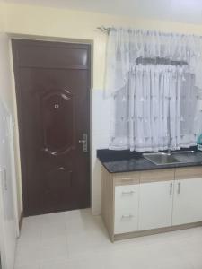 uma cozinha com uma porta preta e um lavatório em Vacay interprime villa #10 em Kitengela 