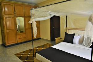 um quarto com uma cama de dossel em Ezeife Guesthouse em Kampala