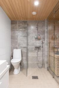 een badkamer met een toilet en een glazen douche bij Top, cozy, lakeside, sauna and free indoor parking in Tampere