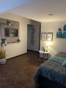 1 dormitorio con 1 cama y 1 mesa con lámpara en Mendoza R km 0 en Mendoza