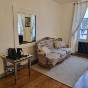 a living room with a couch and a table with a mirror at Chez Jack Confolens in Confolens