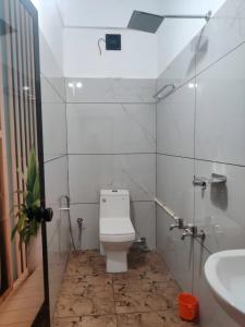 a white bathroom with a toilet and a sink at Spacious 2BHK Near Airport in Cochin