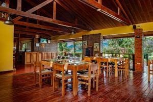 una sala da pranzo con tavoli e sedie in legno di Hotel Villa Florencia a Turrialba