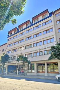 um grande edifício branco com janelas numa rua em Hotel Nahuel Huapi em San Carlos de Bariloche