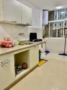 uma cozinha com um balcão e um lavatório em Coquette studio 7 min plage em Agadir