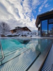 a swimming pool in front of a house at SALZANO Hotel - Spa - Restaurant in Interlaken