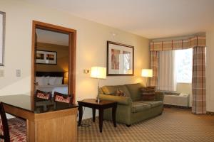 ein Wohnzimmer mit einem Sofa und einem Spiegel in der Unterkunft Country Inn & Suites by Radisson, Lincoln North Hotel and Conference Center, NE in Lincoln
