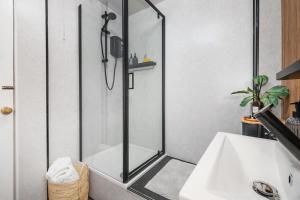 a shower with a glass door next to a sink at Trendy 2 Bed Flat - Near Airport in Broxburn