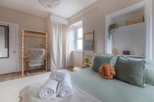 Un dormitorio con una cama azul con toallas. en Trendy 2 Bed Flat - Near Airport en Broxburn