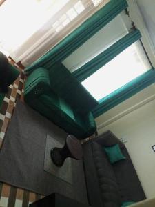 een slaapkamer met een groen bed en een raam bij Eagles one bedroom in Kisii CBD with Balcony in Kisii