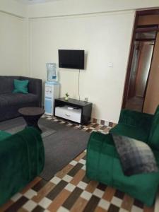 een woonkamer met een bank en een tv bij Eagles one bedroom in Kisii CBD with Balcony in Kisii