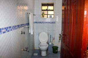 een badkamer met een toilet en een raam bij Eagles one bedroom in Kisii CBD with Balcony in Kisii