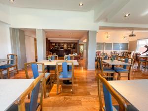 a dining room with tables and blue chairs at Hotel Nahuel Huapi in San Carlos de Bariloche