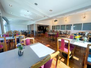 uma sala de jantar com mesas e cadeiras e mesa de cabeceira em Hotel Nahuel Huapi em San Carlos de Bariloche