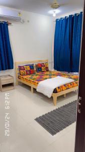 a bedroom with a bed with blue curtains at Stays4you in Baga