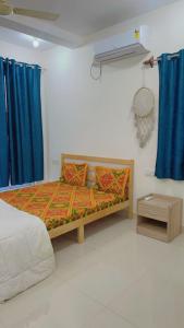 Bett in einem Zimmer mit blauen Vorhängen und einem Bett sidx sidx sidx in der Unterkunft Stays4you in Baga