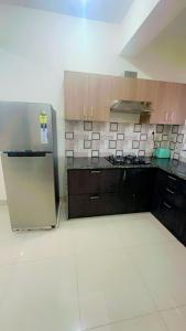 eine Küche mit Holzschränken und einem Kühlschrank aus Edelstahl in der Unterkunft Stays4you in Baga