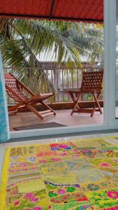 a rug on the floor of a porch with two chairs at Stays4you in Baga