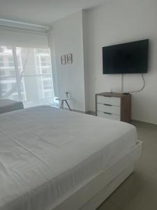 a bedroom with a large bed and a flat screen tv at Apartamento de lujo en Morros Ultra in Cartagena de Indias