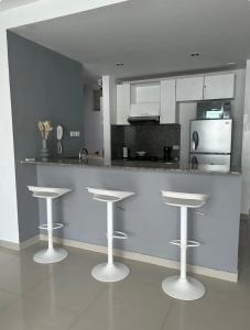 a kitchen with two bar stools and a counter at Apartamento de lujo en Morros Ultra in Cartagena de Indias