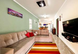 ein Wohnzimmer mit einem Sofa und einem Flachbild-TV in der Unterkunft Otima chacara c Wi-Fi e churrasq em Socorro SP in Socorro