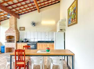 eine Küche mit einem Holztisch und Stühlen in der Unterkunft Otima chacara c Wi-Fi e churrasq em Socorro SP in Socorro
