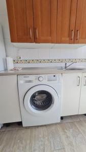 a washing machine in a kitchen with wooden cabinets at Apartamento Ifema Aeropuerto Metropolitano in Madrid
