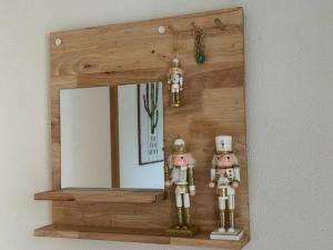 a wooden mirror with two figurines in front of it at Apartamento Ifema Aeropuerto Metropolitano in Madrid