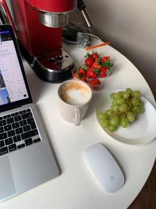 uma mesa com um computador portátil e uma taça de fruta em Cosy apartment near downtown and airport em Vilnius