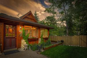 a small wooden house with a fence and a yard at B&B on Mountain Lane - Private Suite & Hot Tub in Banff