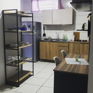 フロリアノポリスにあるLinda Casa Inteira c/ Acesso a Praia do Campecheのテーブル付きのキッチン、白い床のキッチンが備わります。