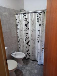 uma casa de banho com um WC e uma cortina de chuveiro em Cabaña Serrana em Santa Rosa de Calamuchita