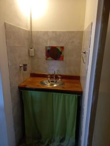 uma casa de banho com um lavatório e uma toalha verde em Cabaña Serrana em Santa Rosa de Calamuchita