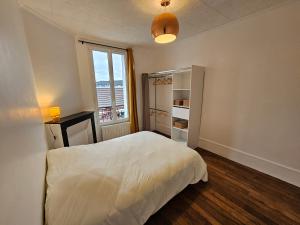 een slaapkamer met een wit bed en een raam bij Le Weber-Paris in Pantin