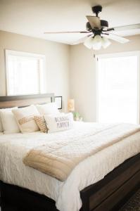 a bedroom with a large bed with a ceiling fan at Nordins Hidden Hillside Cabin in Dardanelle