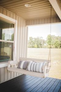 a porch swing with a pillow on a porch at Nordins Hidden Hillside Cabin in Dardanelle