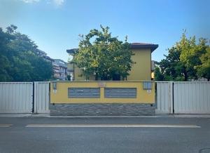 een geel gebouw met een hek ervoor bij "La Casetta dei Ronchi" 300 mt dal mare - posto auto gratuito in Marina di Massa
