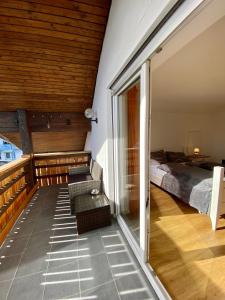 Habitación con cama y balcón con ventana. en Ferienwohnung Kobler, en Görisried