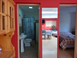 a bathroom with a sink and a toilet and a bedroom at Casa Grilli cerca de la terminal in Río Gallegos