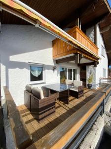 una terraza con mesa y sillas en una casa en Ferienwohnung Kobler, en Görisried